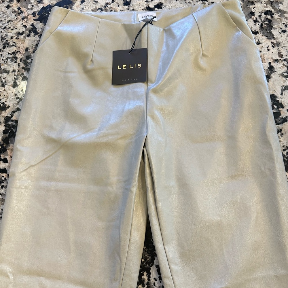 Cream faux leather pants with front slit size large. Brand new with tags.